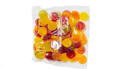Weingummis, Plastikverpackung, Süßwaren, Lebensmittelverpackung, Umweltverschmutzung, Einwegplastik, Lebensmittelindustrie, isoliert, weißer Hintergrund, Verpackungsmüll Weingummis in transparenter Plastikverpackung, isoliert auf weißem Hintergrund.