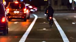 Cyclist drives on the bike path past the traffic jam