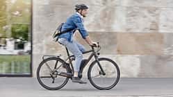 Mann pendelt mit seinem E-Bike zur Arbeit