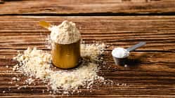 Sports supplements on a wood table background Vertical composition with protein and creatine