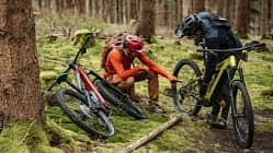 Mountainbike Magazin Zwei Mountainbiker besprechen etwas auf einem Trail, zwei Mountainbikes