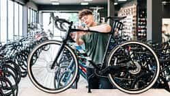 Ein Mann wählt ein Fahrrad in einem Laden aus. 