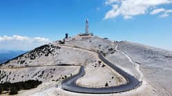 Schmale Autobahn, die zum Mont Ventoux in Frankreich führt, mit blauem Himmel im Hintergrund.