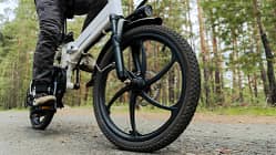 Radfahrer fährt auf einem Radweg im Wald. Fahren mit einem modernen Elektrofahrrad.