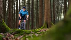Cyclist riding gravel bike on a forest trail in Germany