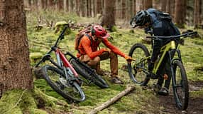 Zwei Mountainbiker besprechen etwas auf einem Trail, zwei Mountainbikes