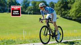 Radfahrerin im sportlichen Antritt auf der BMC Roadmachine mit Komfort Testsiegel von ROADBIKE.