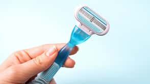 Women razor in hand isolated on a blue background. Close-up. Beauty concept. Women razor in hand isolated on a blue background. Close-up. Beauty concept.
