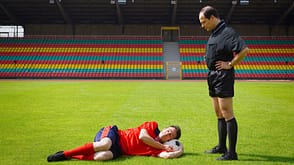 caucasian,coaching,hands on hips,laying,man,soccer,soccer pitch,soccer stadium,unhappy Soccer coach watching player sleeping on ball on sunny pitch