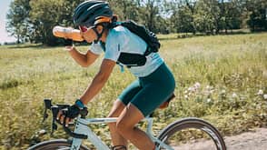 frau,outdoor,rennrad,sommer,sonne,trinken,trinkflasche Viele Rennräder werden ihrem Namen heute auch jenseits des Asphalts gerecht. Anstrengender ist das Fahren dort allerdings weiterhin.