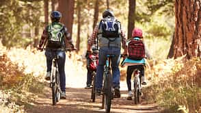 Travel,Sports Helmet,People Traveling,Wilderness Area,Pre-Adolescent Child,Girls,Women,Boys,Men,Four People,Copy Space,Hobbies,30-39 Years,Mature Adult,Adult,Backpack,Exercising,Caucasian Ethnicity,Mountain Bike,Bonding,Adventure,Exploration,Tranquil Scene,Safety,Vacations,Nature,Outdoors,Full Length,Horizontal,Rear View,Mountain Biking,Cycling,Recreational Pursuit,Son,Daughter,Mother,Father,Parent,Family,Autumn,Forest,Bicycle Family mountain biking on forest trail, back view