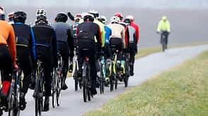 A group of cyclists on a bicycle path on a foggy autumn day A group of cyclists on a bicycle path on a foggy autumn day