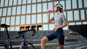 Cyclist woman drinking water after training Cyclist woman drinking water after training