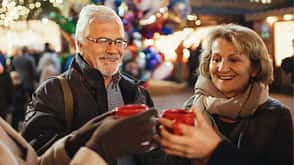 Glühwein, Weihnachten, Weihnachtsmarkt, Schnee, Winter, Alkohol Ältere Herrschaften mit Glühweintassen