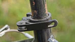 part of a metal tube with an iron clamp and a black plastic handle