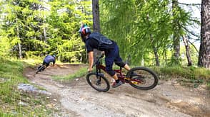 Two boys riding downhill on a pathway in the forest. Two boys riding downhill on a pathway in the forest.
