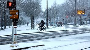 Ein Fahrradfahrer auf den Straßen von Paris bei Schneefall 