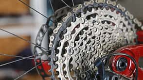 Detailaufnahme einer Fahrrad-Kassette mit Kette am Hinterrad, Fokus auf Ritzelpaket und Schaltwerk.