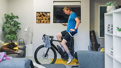 Man using his cycling turbo trainer in the living room