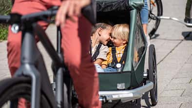 Kindertransport Fahrrad I Kinderanhänger I Fahrbild mit zwei Kindern