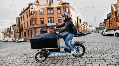 E-Lastenrad I Test Chike E-Cargo I Fahrbild Frau mit geschlossener Transportbox