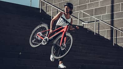 Frau trägt leichtes E-Bike Treppenstufen herab