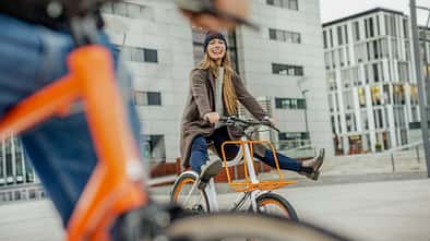 Carefree woman with man riding bicycle in the city