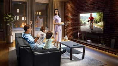 Family with children cheering and watching Cycle race on TV