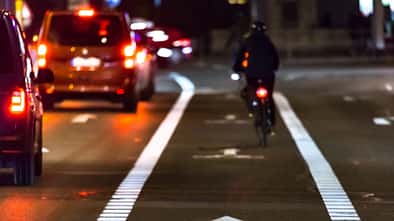 Cyclist drives on the bike path past the traffic jam