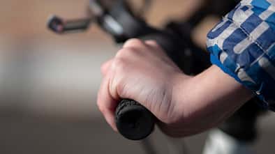 Close up view of a teenagers hand on the bicycle handlebars