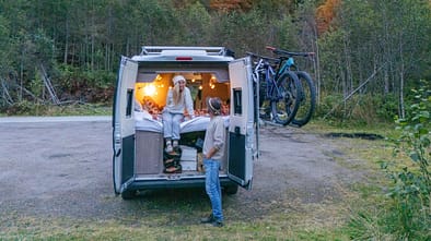 A Couple Experiencing Cozy Van Life Adventure in Autumn Forest