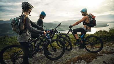 Group of friends mountainbike riders: MTB biking outdoor up mountain of Norway
