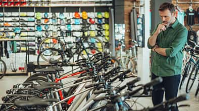 man checking out bicycles in bike shop