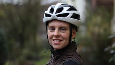 Portrait einer Radfahrerin, die den Rudy Rebel Helm trägt. 