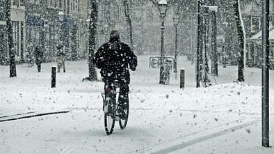 Ein Biker wagt es, mit dem Fahrrad auf dem frischen Schnee zu fahren.
