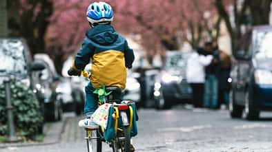Ein kleiner Junge radelt in einer Straße.
