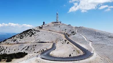Schmale Autobahn, die zum Mont Ventoux in Frankreich führt, mit blauem Himmel im Hintergrund.