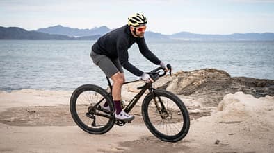 Orbea Terra M20iTeam,Gravelbike,Test,Actionfoto,schräg ankommend an Küste,Meer