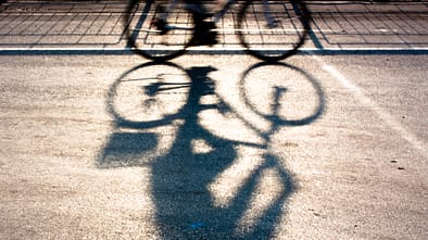 Schatten eines Radfahrers auf dem Asphalt. 