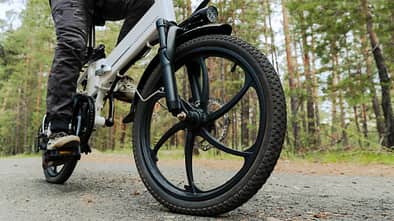 Radfahrer fährt auf einem Radweg im Wald. Fahren mit einem modernen Elektrofahrrad.
