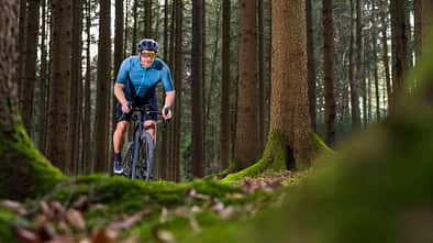 Cyclist riding gravel bike on a forest trail in Germany