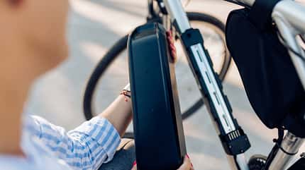 Unrecognizable woman changing batteries on her electric bicycle Unrecognizable woman changing batteries on her electric bicycle