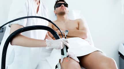 Young beautician removing legs hair with a laser to her client in the beauty salon. Young beautician removing legs hair with a laser to her client in the beauty salon.