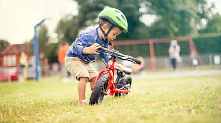 Kind mit rotem Laufrad von Frog Bikes Kind mit rotem Laufrad von Frog Bikes