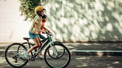 Zwei Mädchen fahren auf ihren Woom Bikes Zwei Mädchen fahren auf ihren Woom Bikes