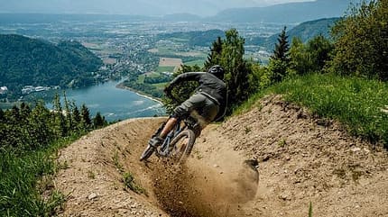 Mountainbike, Österreich, Prolitzenline, Anlieger, Steilkurve Ein Biker fährt durch eine Steilkurve mit Blick auf den Ossiachersee