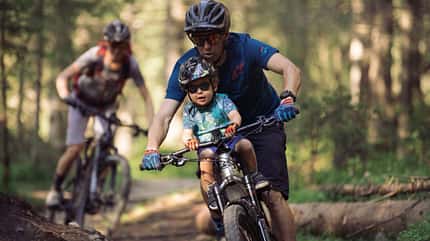 Kindertransport Fahrrad I Kindersitz I Fahrbild Mountainbiker mit Kind im Kindersitz vorn Kindertransport Fahrrad I Kindersitz I Fahrbild Mountainbiker mit Kind im Kindersitz vorn
