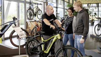 Verkaufsgespräch zwischen Fahrrad-Händler und Kunden Verkaufsgespräch zwischen Fahrrad-Händler und Kunden
