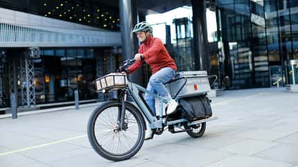 Stuttgart bei LBW-Bank, Frau auf E-Lastenrad des Herstellers Decathlon, Modell BTWIN Elops R500 E Longtail Stuttgart bei LBW-Bank, Frau auf E-Lastenrad des Herstellers Decathlon, Modell BTWIN Elops R500 E Longtail