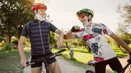 mountain bike friends elbow bump during pandemic mountain bike friends elbow bump during pandemic